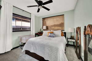 Carpeted bedroom featuring ceiling fan