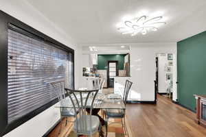 Dining space with hardwood / wood-style flooring and a textured ceiling