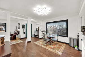 Dining room with wood-type flooring and an AC wall unit