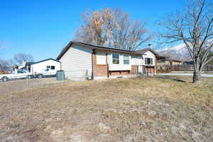 View of front of property featuring a front yard and central air condition unit