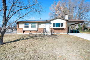 Bi-level home with a carport and a front yard