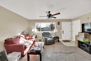 Living room featuring light carpet and ceiling fan