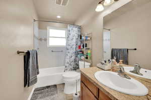 Full bathroom with tile patterned flooring, vanity, shower / bath combo with shower curtain, and toilet