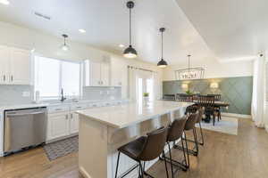 Kitchen with white cabinets, dishwasher, and a kitchen island