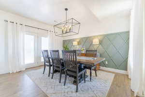 Dining space with light hardwood / wood-style floors and a chandelier