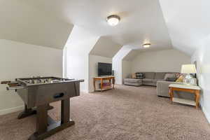 Recreation room featuring carpet flooring and vaulted ceiling