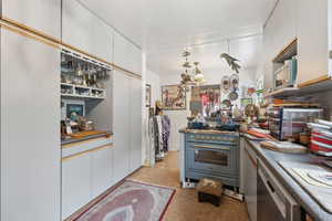 Kitchen with white cabinetry, black dishwasher, and high quality range