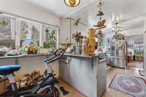 Kitchen with a chandelier, kitchen peninsula, and stainless steel fridge with ice dispenser