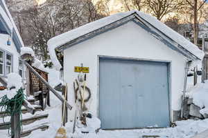 Snow covered structure with a garage