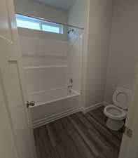 Master Bathroom with hardwood / wood-style floors, shower / bathtub combination, and toilet