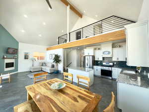 Dining area featuring sink, high vaulted ceiling