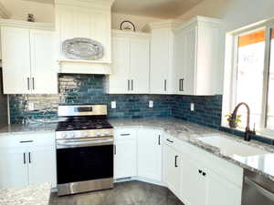 Kitchen featuring white cabinetry, sink, and appliances with stainless steel finishes