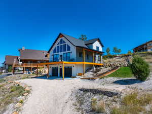 Back of property featuring a garage and a deck