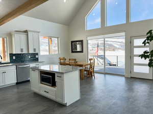 Kitchen featuring white cabinetry, light stone counters, and appliances with stainless steel finishes