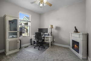 bedroom main level being used as office space featuring ceiling fan
