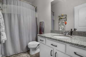 Hall Bathroom with a shower, vanity, and toilet