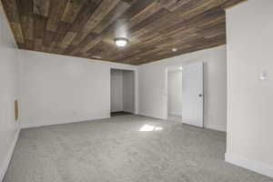 Basement with carpet flooring and wood ceiling
