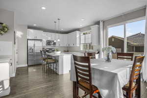 Dining room with dark hardwood / wood-style floors and sink