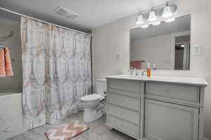 Brand new finished basement never been used-Bathroom featuring vanity, curtained shower, and toilet