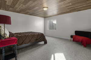 Carpeted bedroom featuring wood ceiling