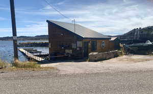 View of home's exterior featuring a water view and a boat dock