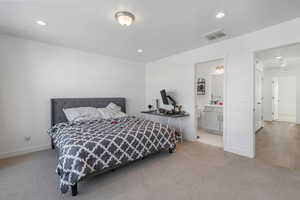 Bedroom with light colored carpet and ensuite bathroom