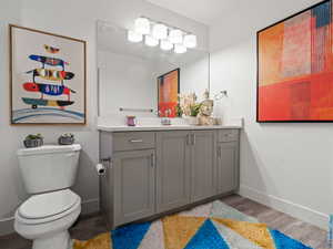 Bathroom featuring wood-type flooring, vanity, and toilet