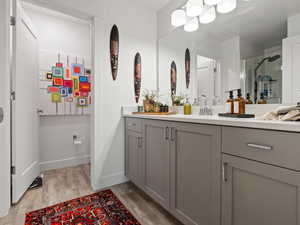 Bathroom featuring hardwood / wood-style flooring, vanity, and a shower with door