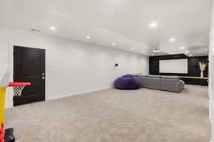 Home theater room featuring light colored carpet