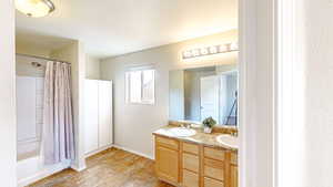 Bathroom featuring vanity and shower / bathtub combination with curtain