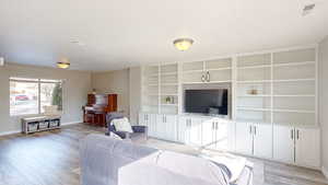 Living room featuring light hardwood / wood-style flooring and built in features