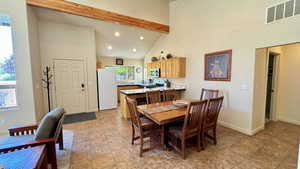 Dining room with beamed ceiling and high vaulted ceiling