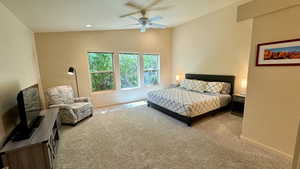 Bedroom with light carpet, vaulted ceiling, and ceiling fan