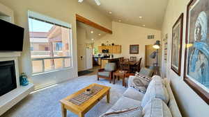 Living room with light carpet and high vaulted ceiling