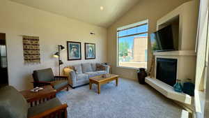 Carpeted living room with lofted ceiling