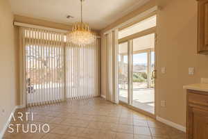 Unfurnished dining area featuring light tile patterned flooring, a golf course and mountain view