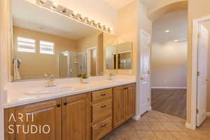 Master bathroom with tile patterned flooring, double vanity, a textured ceiling, and walk in shower