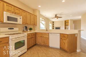 Kitchen featuring light tile patterned flooring, sink, kitchen peninsula, and white appliances