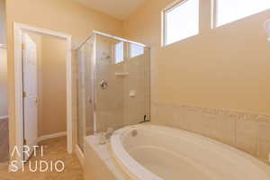 Master bathroom with tile patterned floors and separate shower and tub