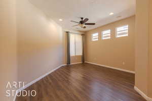 Master bedroom with ensuite bathroom with ceiling fan and dark lvp sytle flooring and a ceiling fan