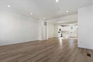 Unfurnished living room with hardwood / wood-style floors and sink