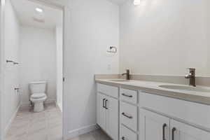 Bathroom with vanity, tile patterned floors, and toilet