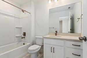 Full bathroom with shower / bath combination, vanity, and toilet