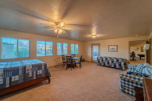 Carpeted bedroom featuring ceiling fan