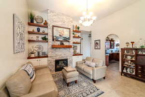 Tiled living room with a fireplace and a notable chandelier