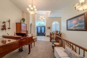 Misc room featuring light colored carpet, a chandelier, and french doors