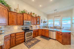 Kitchen featuring tasteful backsplash, stainless steel appliances, kitchen peninsula, and hanging light fixtures