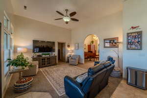 Tiled living room with a high ceiling and ceiling fan