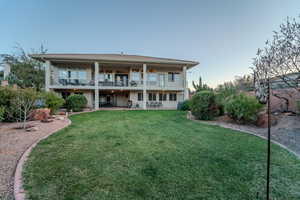 Back of house with a patio, a balcony, and a yard