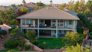 Back of property with a balcony, a yard, and a patio area